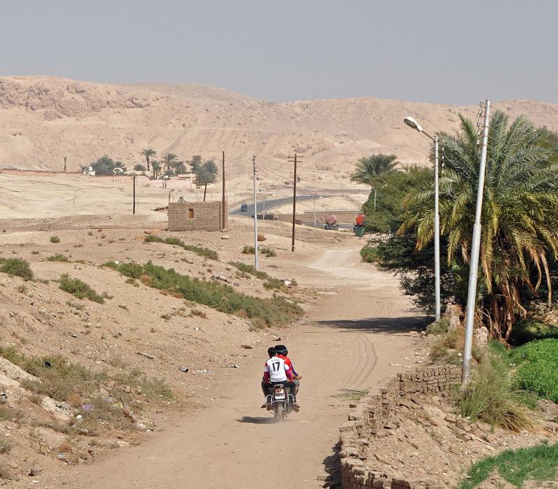 A motorcyclist on a dusty village road on Luxor's West Bank